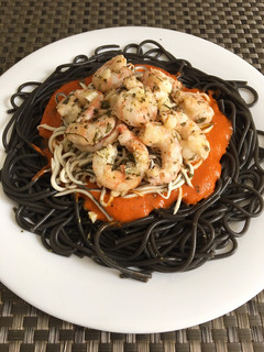 Una foto de Espaguetis negros con gulas, langostinos y salsa de pimientos rojos