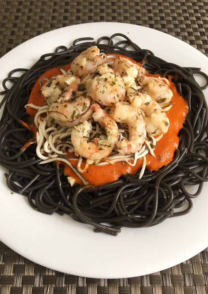 Una foto de Espaguetis negros con gulas, langostinos y salsa de pimientos rojos