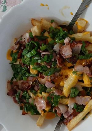 Una foto de Papas fritas con cheddar y bacon
