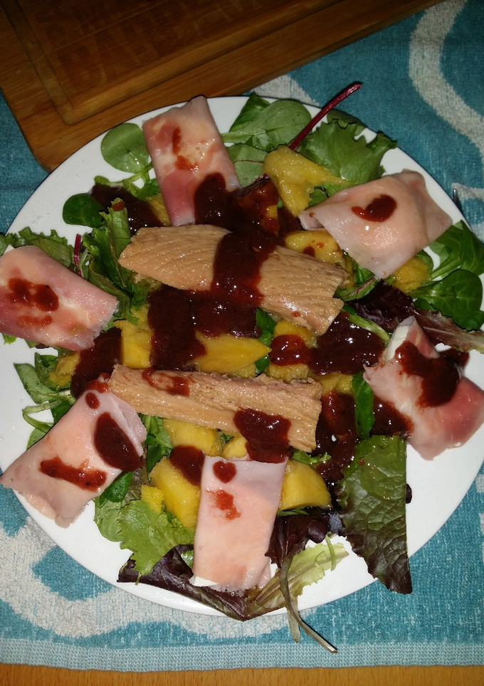 Una foto de Ensalada de mango brotes tronco de atún, rollos de queso fresco y york con vinagreta de frutos rojos