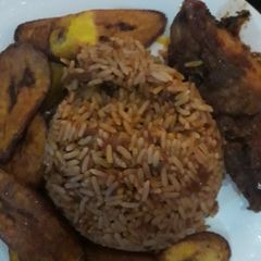 A picture of Jellof rice, plantain and chicken.
