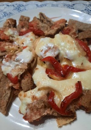 Una foto de Milanesa con tomate, tiras de morrón y queso