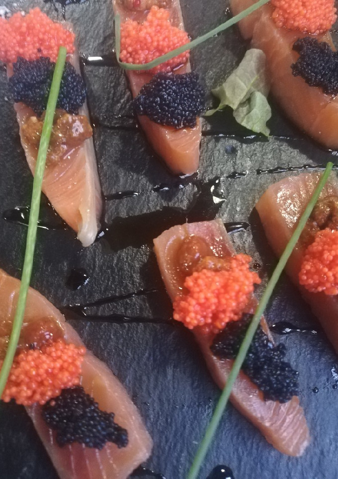 Una foto de Salmón marinado con caviar de erizo y huevas de lumpo