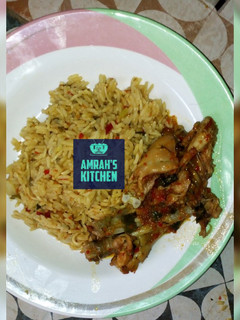 A picture of Jollof rice with pepperd chicken.