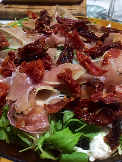 Una foto de Ensalada de Burrata, rúcula, tomates secos y jamón crudo
