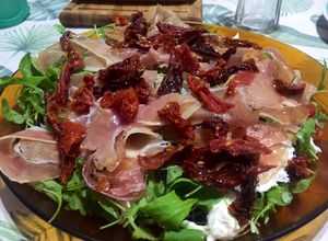 Una foto de Ensalada de Burrata, rúcula, tomates secos y jamón crudo