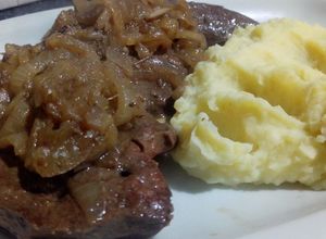 Una foto de Bife de hígado encebollado con guarnición de puré de papas