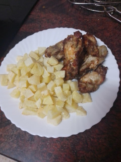Una foto de Jamoncitos de pollo embarrados en mojo y asados en freidora de aire con papas fritas