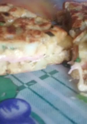 Una foto de Tortilla de papa rellena de paleta y queso