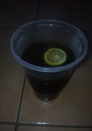 A picture of Black coffee with a lemon.