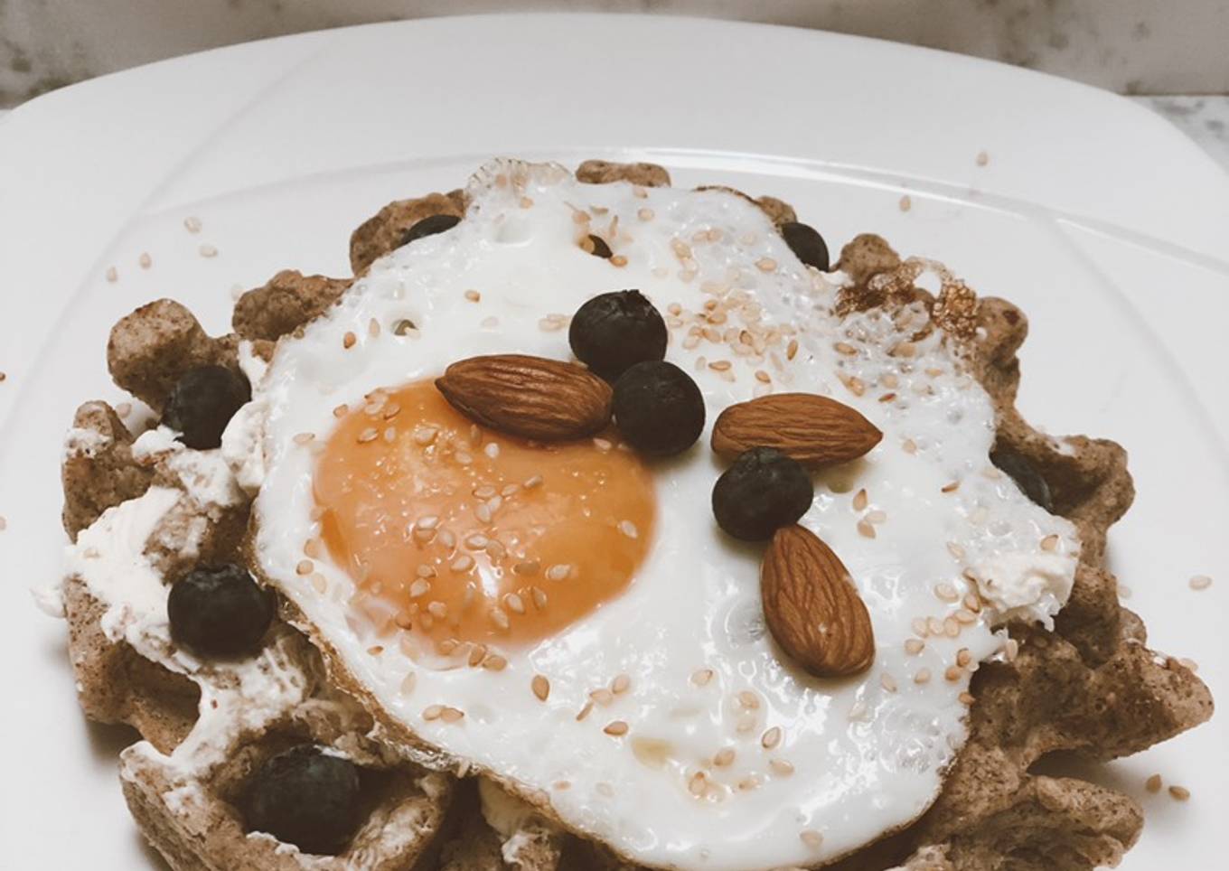 Waffles 🧇 de avena con huevo frito, queso crema de almendras y arándanos con semillas de ajonjolí ⚡️