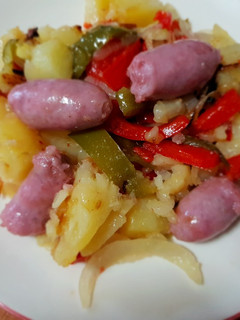 Una foto de Salchipatatas confitadas con pimientos y cebolla