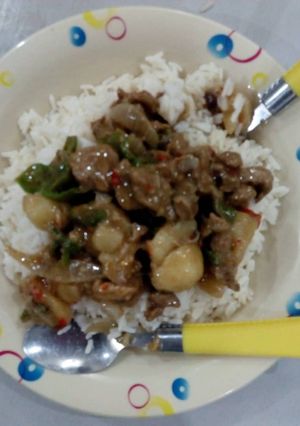 A picture of White rice with beef soup.