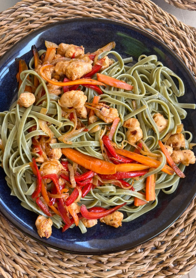 Una foto de Tallarines de espinacas con verduras y salchichas