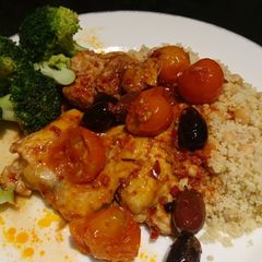 A picture of Harissa chicken with olives and tomatoes.