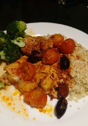A picture of Harissa chicken with olives and tomatoes.