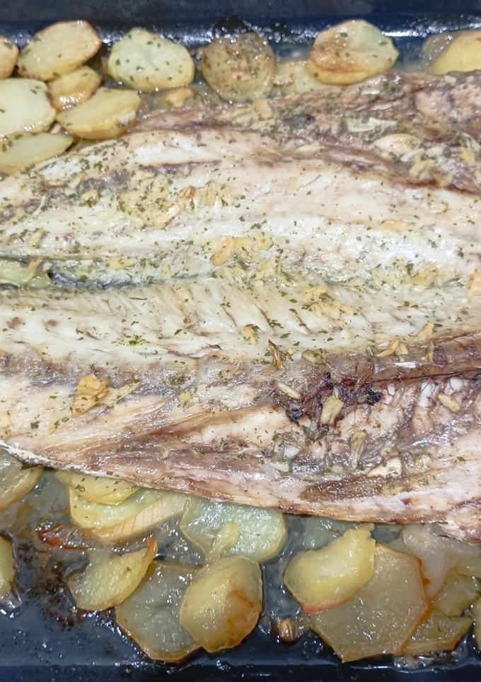Una foto de Corvina al horno con patatas y cebolla