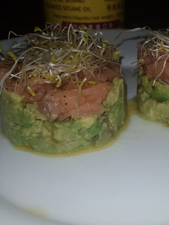 Una foto de Tartar de salmón y aguacate con aceite de sésamo y alfalfa