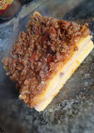 Una foto de Polenta Rellena de jamón y queso con boloñesa