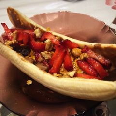 A picture of Healthy banana split boat for breakfast. With granola and almond butter.