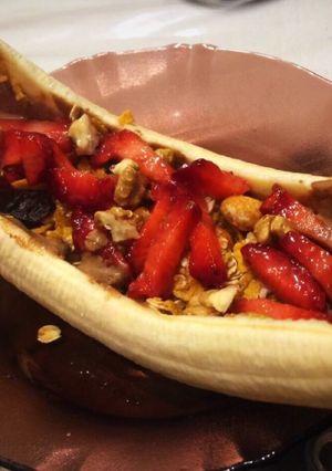 A picture of Healthy banana split boat for breakfast. With granola and almond butter.