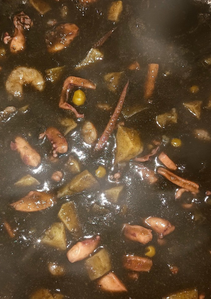 Una foto de Potas en su tinta con patatas