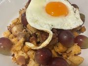 Una foto de migas con embutido y fruta