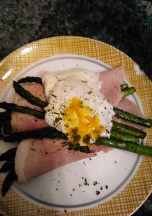 A picture of Asparagus topped with poached egg.