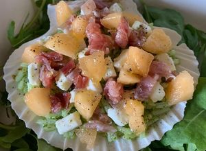 Foto di Conchiglia con riso al pesto di rucola, feta, petali di speck e melone