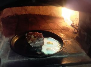 Una foto de Pecho de cerdo con huevos de campo al horno de barro