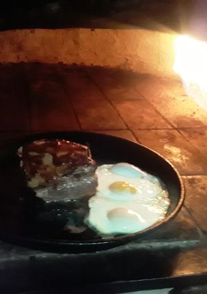 Una foto de Pecho de cerdo con huevos de campo al horno de barro