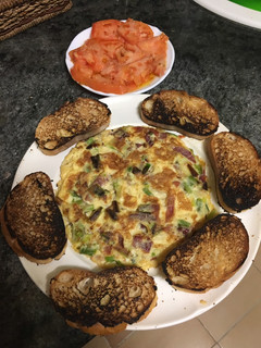 Una foto de Tortilla de ajetes y jamón con tomate natural