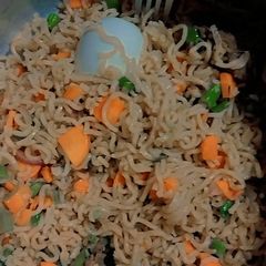 A picture of Garnished noodles with boiled egg and beef meat.