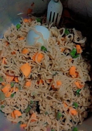 A picture of Garnished noodles with boiled egg and beef meat.