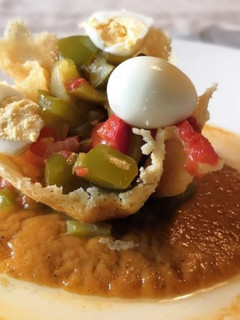 Una foto de Pisto con crujiente de parmesano y huevos de codorniz