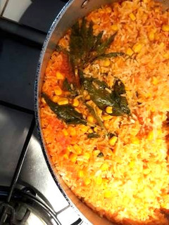 Una foto de Arroz rojo con granos de elote y epazote
