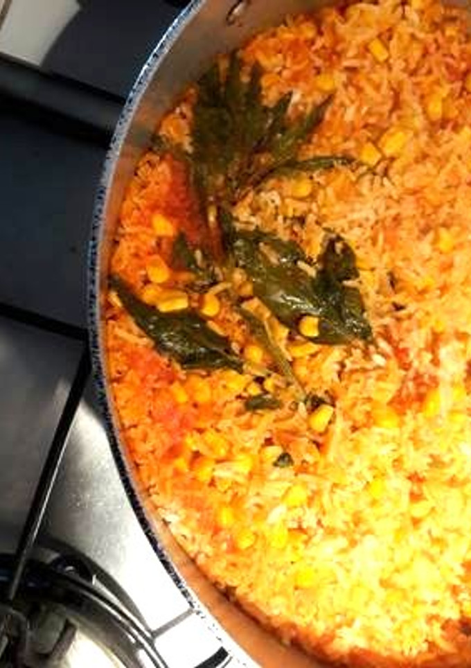 Una foto de Arroz rojo con granos de elote y epazote