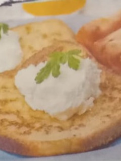 A picture of French toast served with sour cream and fresh tomato.