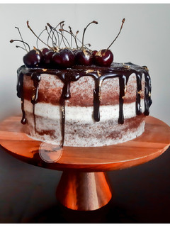 A picture of Dark Chocolate Drip cake with Cream cheese and Cherry Jam.