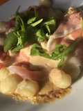 Ñoquis con salsa de queso, prosciutto y rúcula