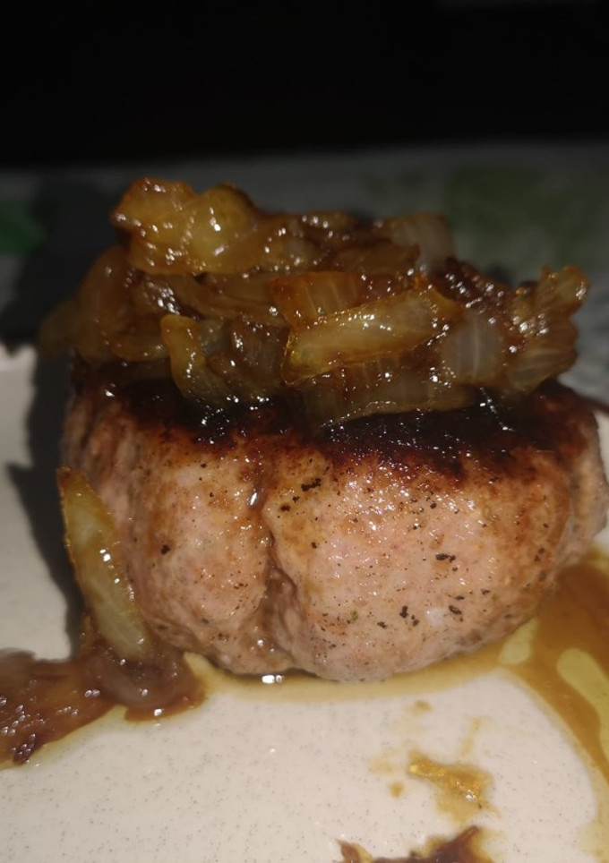 Una foto de Hamburguesa casera con queso y cebolla caramelizada