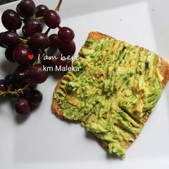 A picture of Mashed 🥑 avocado on bed of toasted bread.