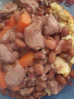 A picture of Pinto beans with pork over cornbread.