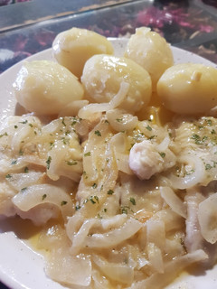 Una foto de Merluza encebollada con papas