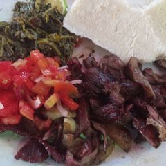 Nyama choma with traditional vegetables and Kachumbari A picture of Nyama choma with traditional vegetables and Kachumbari.