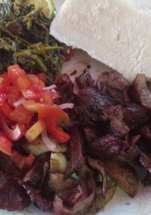 A picture of Nyama choma with traditional vegetables and Kachumbari.