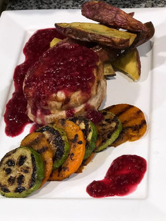 Una foto de Medallones de cerdo con salsa de arándanos + guarnición de batatas picantes y vegetales grillados