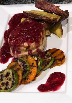 Una foto de Medallones de cerdo con salsa de arándanos + guarnición de batatas picantes y vegetales grillados