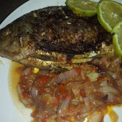 A picture of Grilled fish with onion sauce.