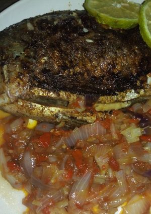 A picture of Grilled fish with onion sauce.
